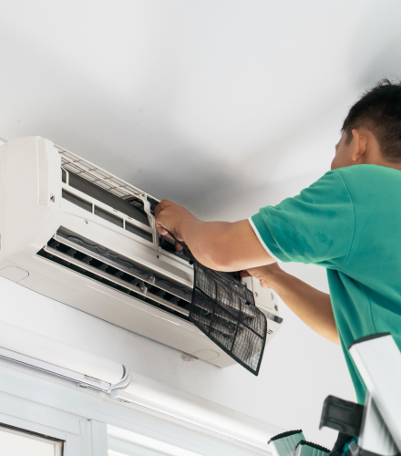 Especialista reparando aire acondicionado en hogar